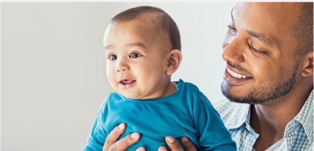 image of a smiling man, holding and looking down at a laughing baby